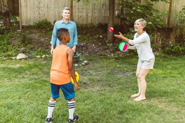 A cheerful family enjoying outdoor playtime in a sunny backyard, fostering family bonding.