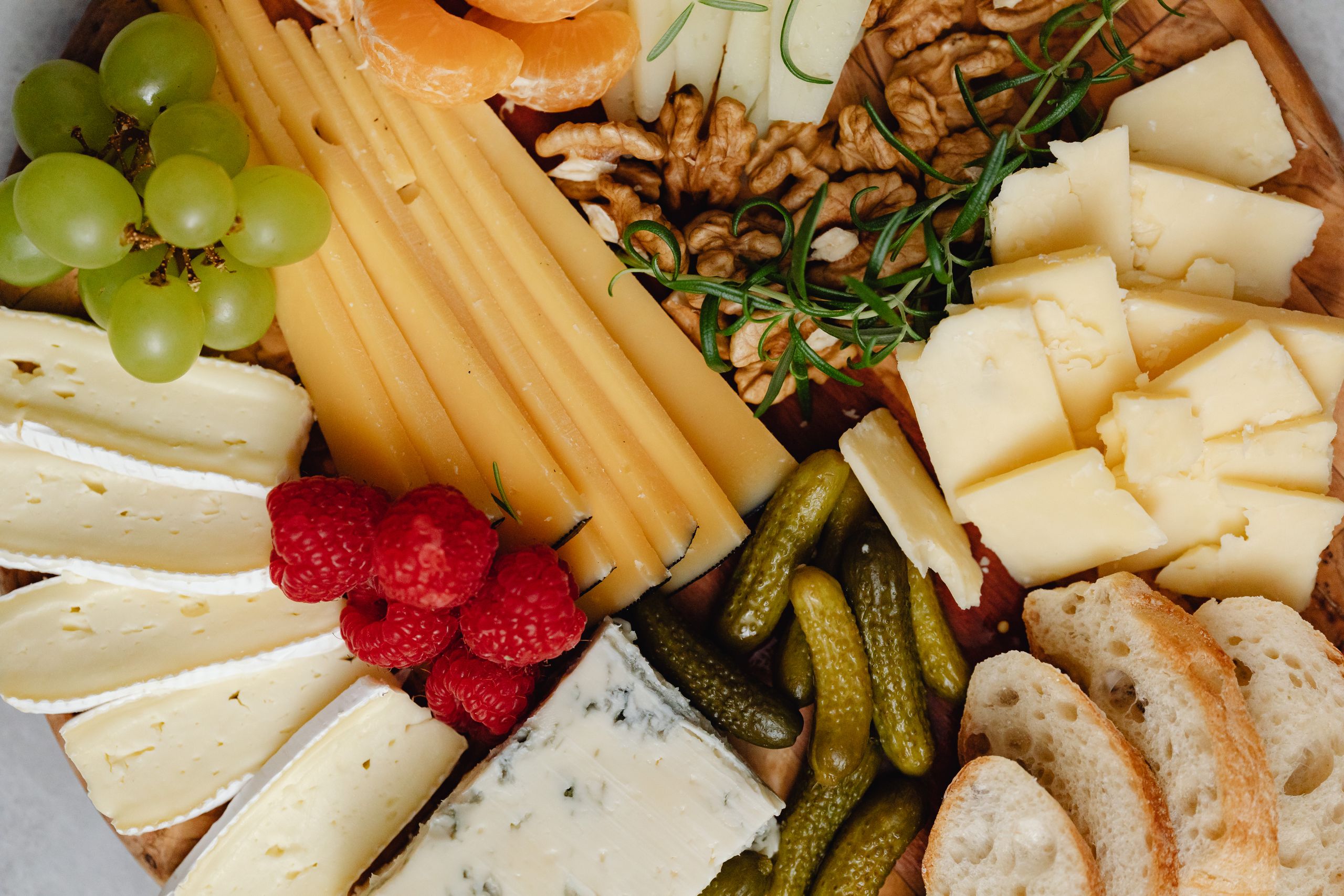 A delicious assortment of cheeses, fruits, nuts, and bread arranged on a charcuterie board.