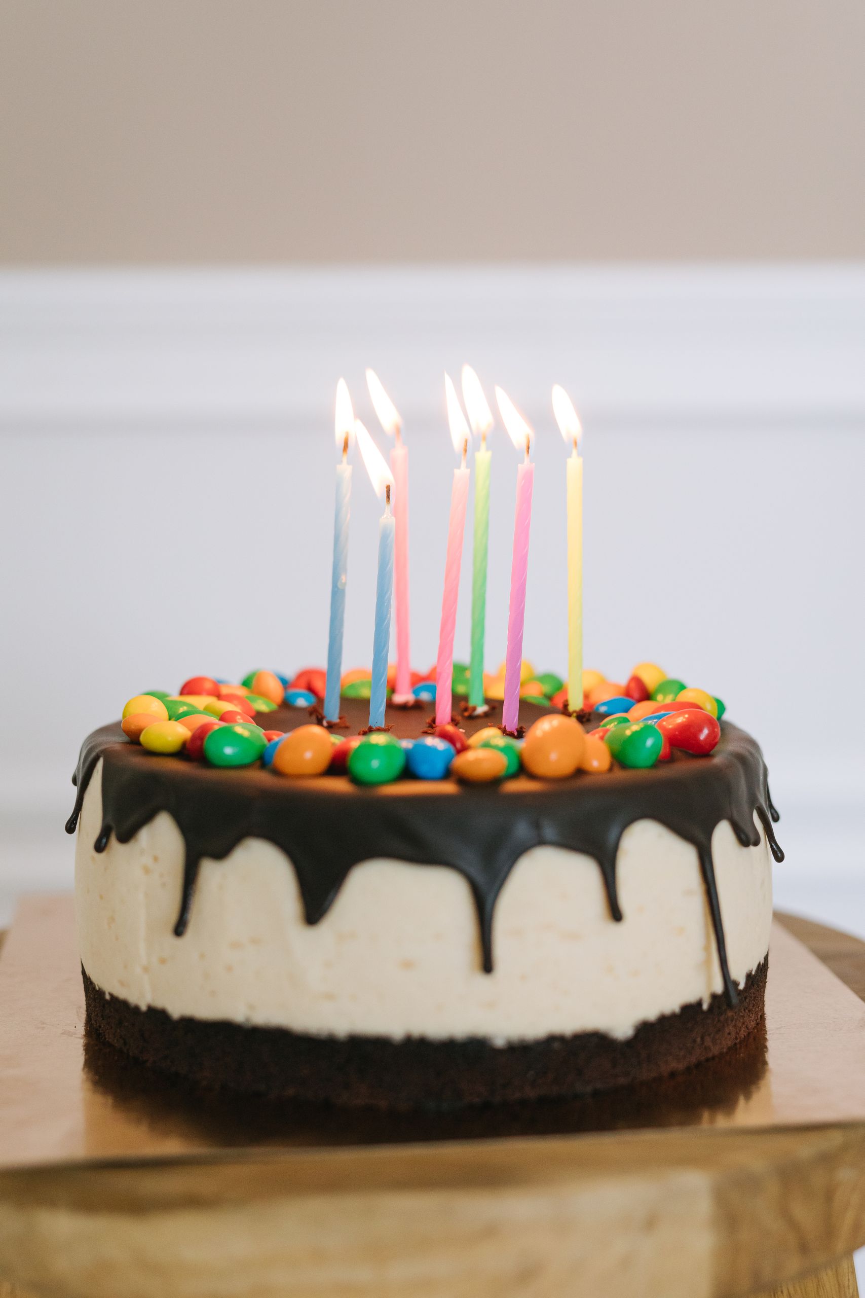 A vibrant birthday cake adorned with colorful candies and lit candles.