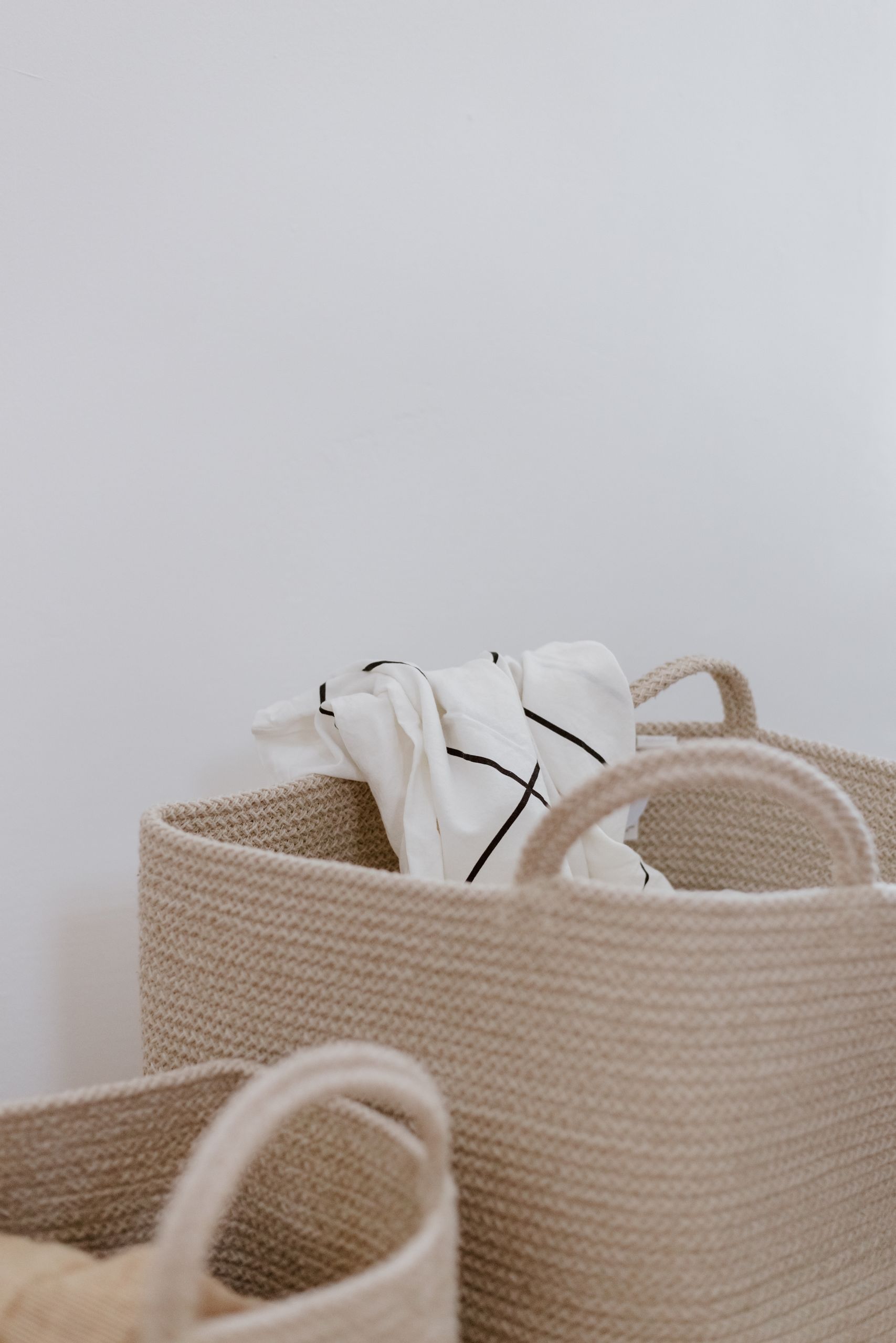 Cozy storage baskets with rolled linens, perfect for minimalist home decor.