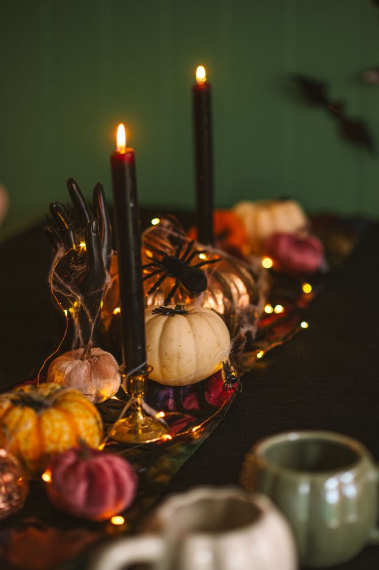 Festive Halloween table centerpiece with pumpkins, candles and decorative lights