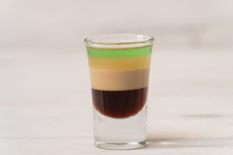 Vibrant layered Halloween jello shot with distinct yellow, orange, and white layers