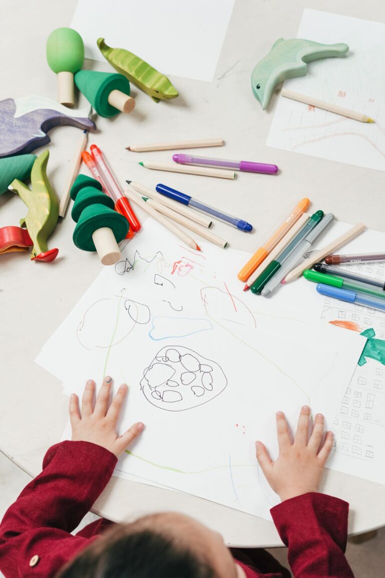 Child drawing with colored pencils at a table, ready to sketch a sleepy cat