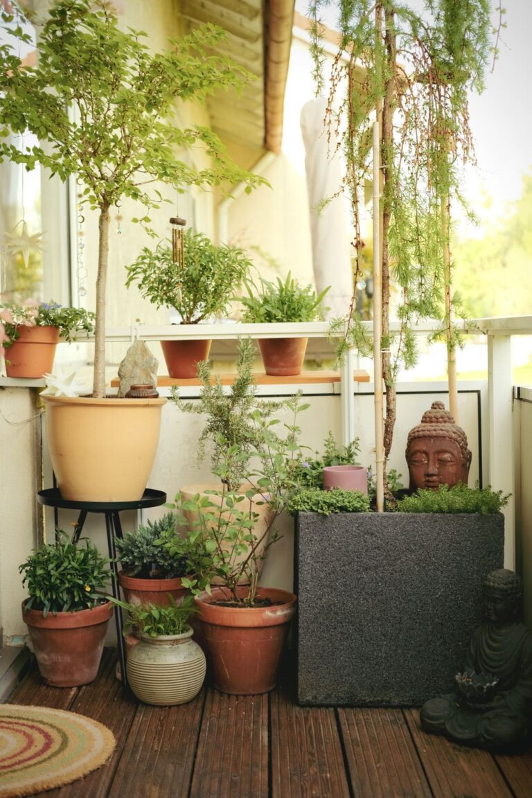 A tranquil balcony decorated with Buddha statues, potted plants, and decorative figures. Stock Photo.