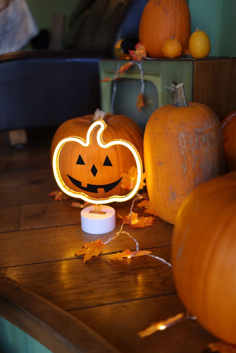 Dorm corner with pumpkins, autumn leaves and a jack-o'-lantern neon light