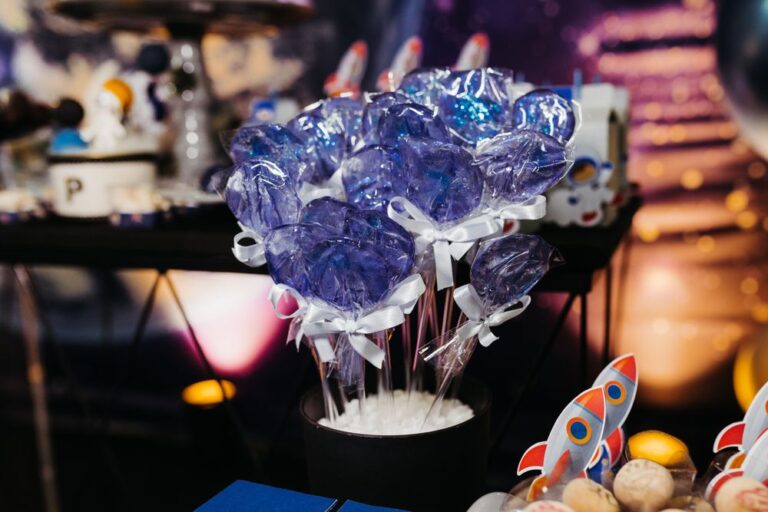 Vibrant blue lollipops arranged in a black container, perfect for party table decor. Stock Photo.