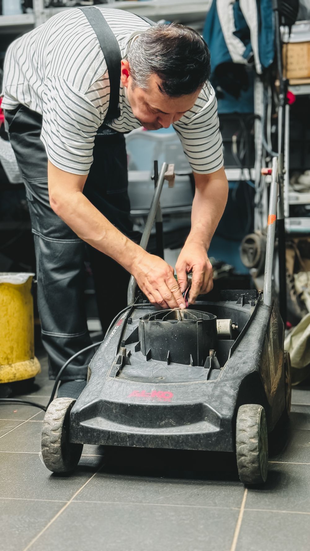 Lawn mower parked in a tidy garage workshop corner