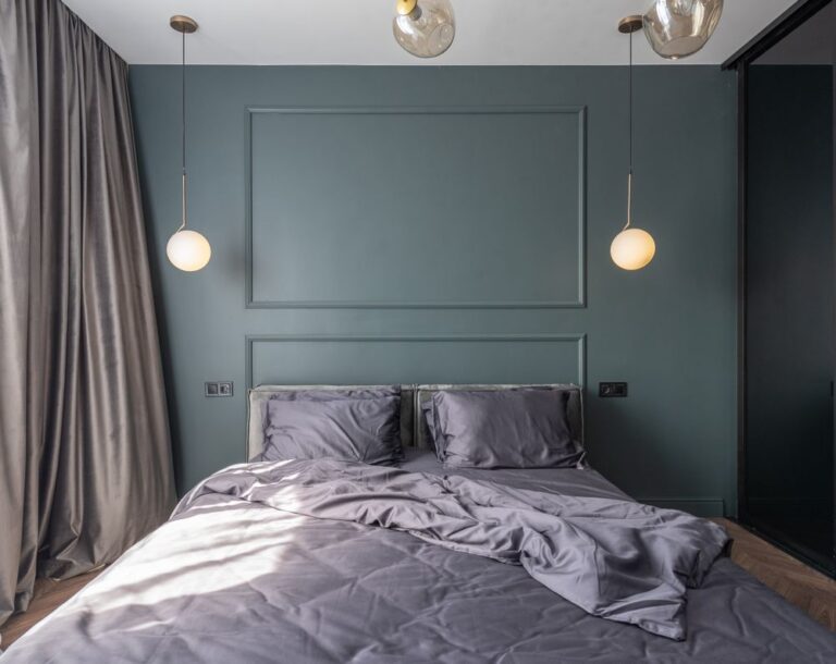 Interior design of modern bedroom with unmade bed under luminous lamps at sunlight Stock Photo.