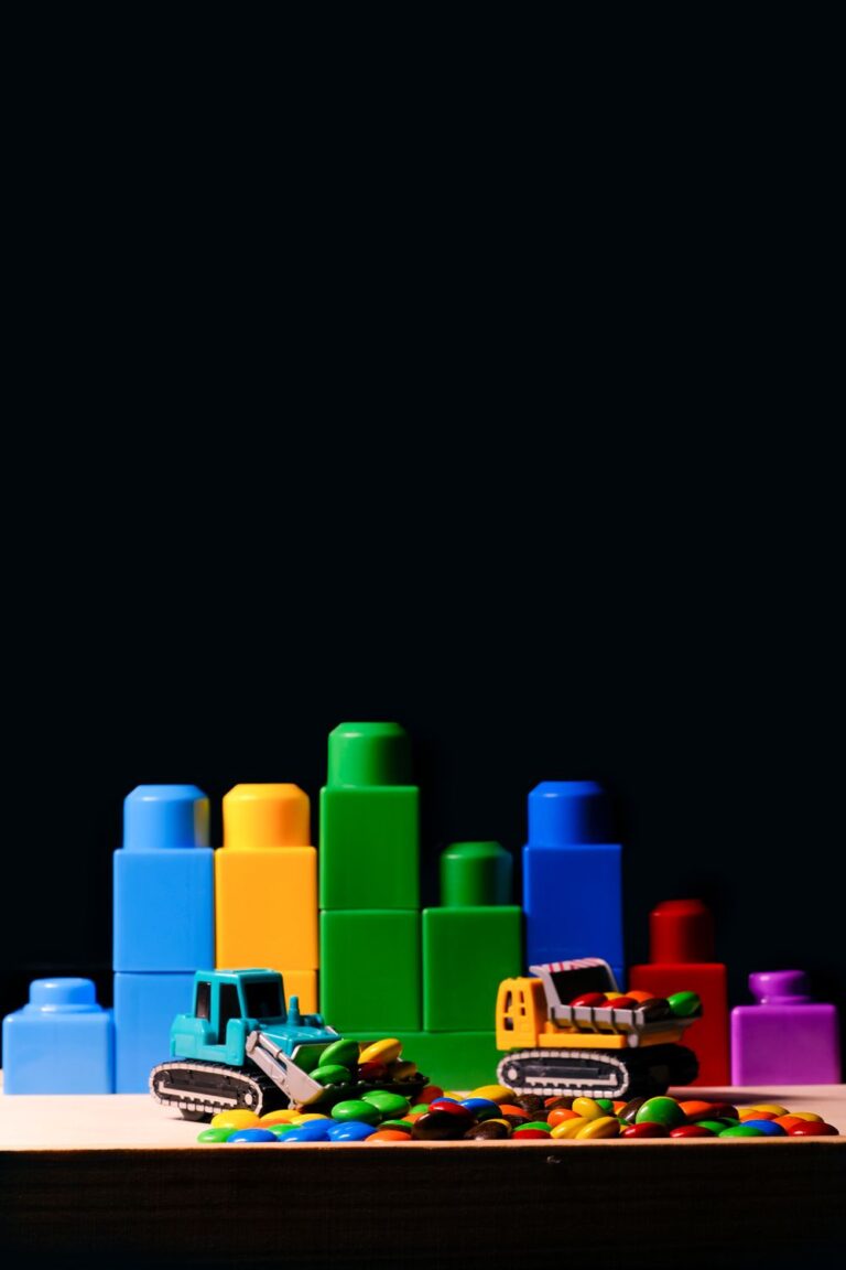 Colorful building bricks and toy vehicles spread on a wooden surface ready for free building and quick storage