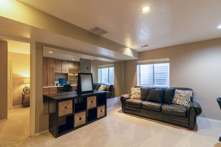 Warm and inviting basement living room featuring a leather sofa and modern decor. Stock Photo.