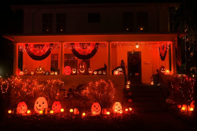 Spooky Halloween porch decorated with glowing pumpkins and orange lights