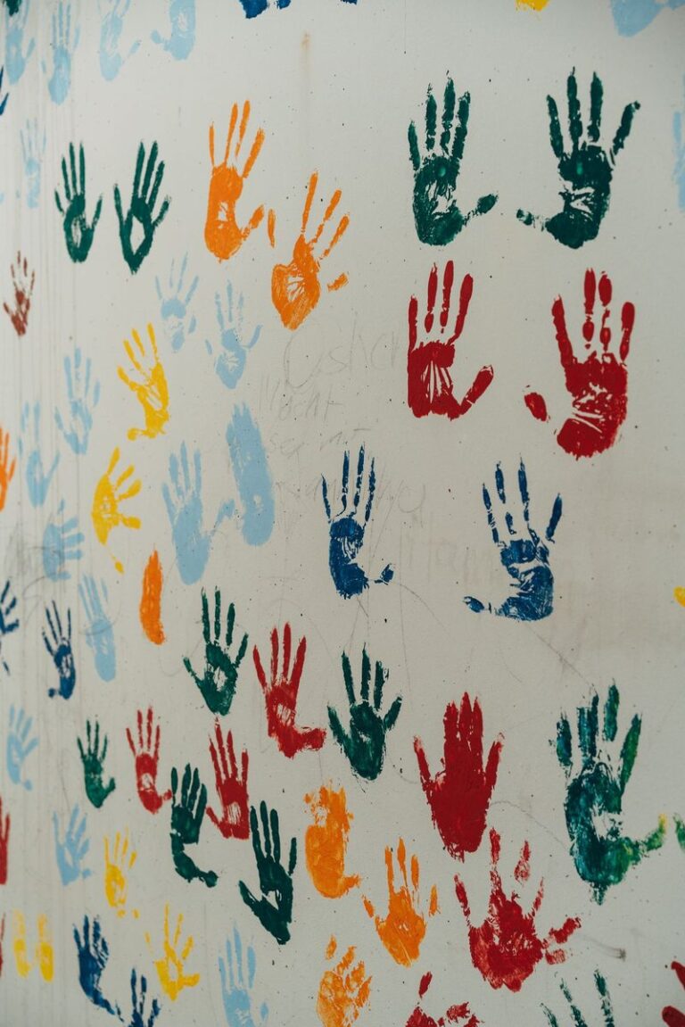 A wall with many colourful hand prints on it, handprint crafts for kids