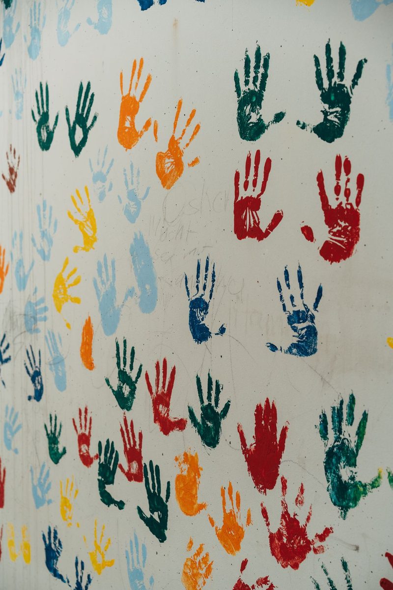 A wall with many colourful hand prints on it, handprint crafts for kids