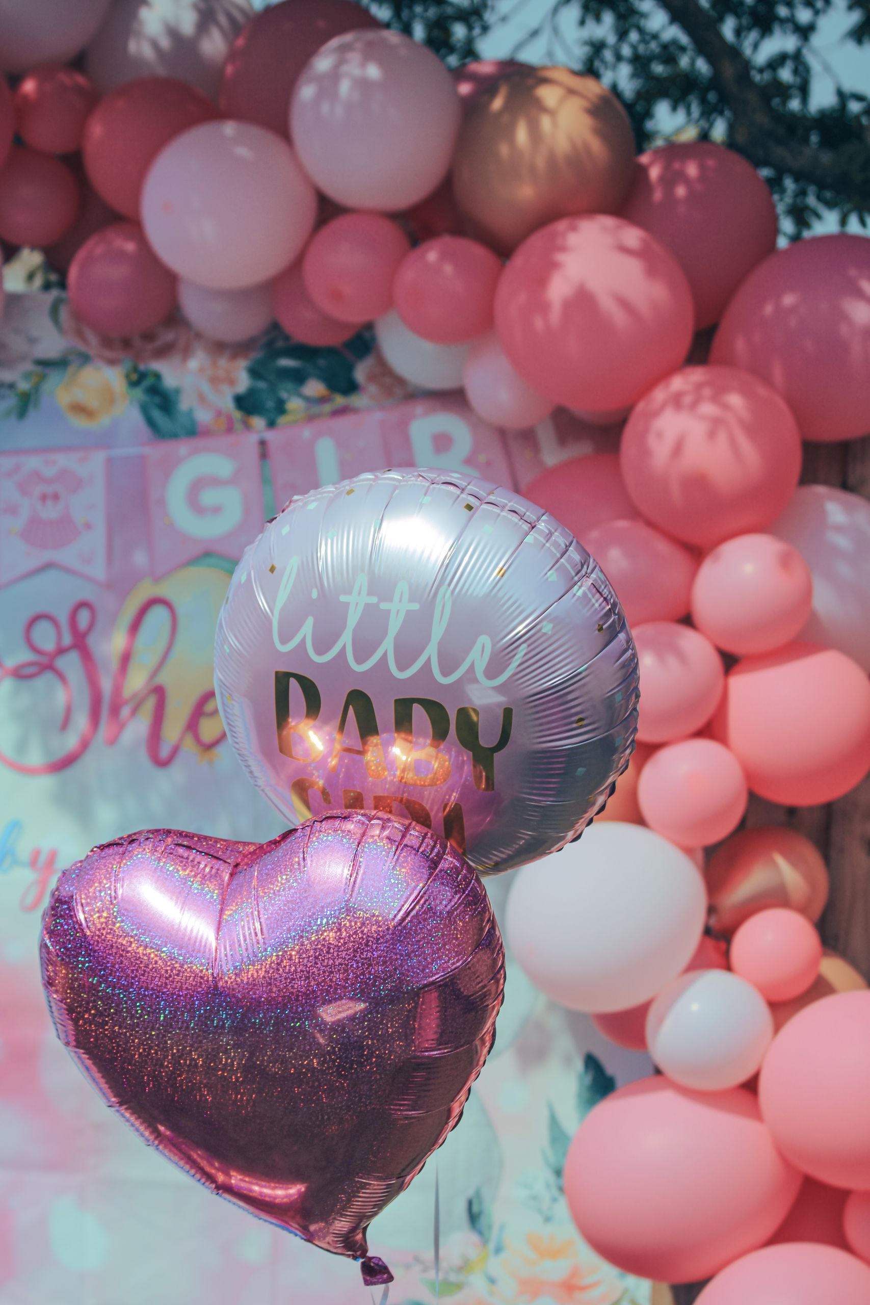Pink-themed baby shower decor with heart and round balloons creating a joyful atmosphere.