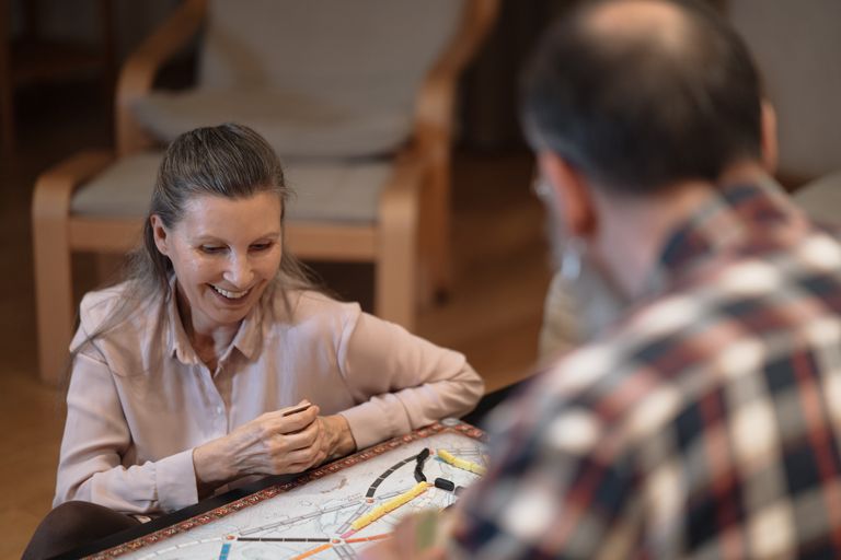Smiling couple enjoying a board game together in a cozy living room setting.