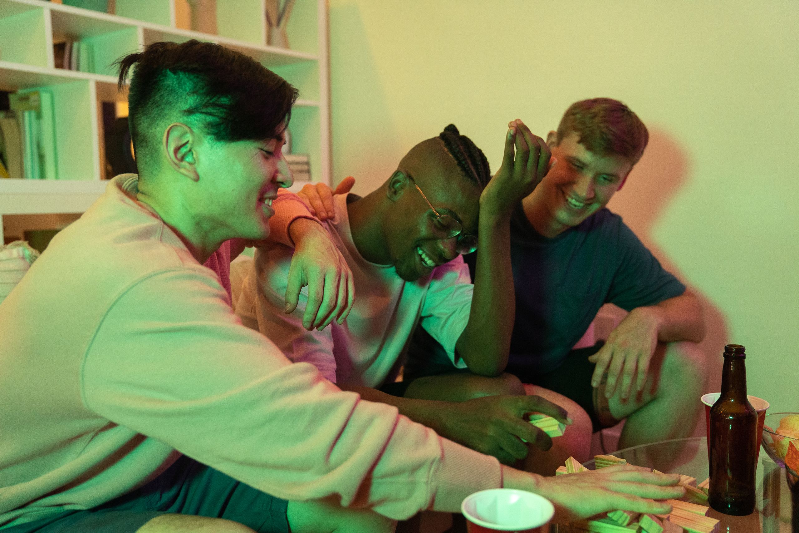 Three friends having fun playing a game at home, enjoying a relaxed and joyful evening together.